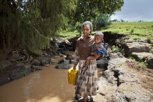 On 3 August, Montegbosh carries her 18-month-old son, Zerihun, as she collects water from a creek in Odoleka Village, Oromia Region. Drought and failed crops have left Montegboshs family hungry. Although she is able to feed Zerihun breastmilk, she eats only false banana, a starchy root vegetable. Her four-year-old son is not getting enough nutritious food, and the family does not have enough money to purchase milk. To make matters worse, the village pump broke several days ago. Villagers are now forced to use muddy water from the nearby creek for drinking and cooking. [#3 IN SEQUENCE OF THREE] In late August 2011, the crisis in the Horn of Africa  affecting primarily Kenya, Somalia, Ethiopia and Djibouti  continued, with a worsening drought, rising food prices and ongoing conflict in Somalia. The regions worst drought in 60 years has left 12.4 million people in need of assistance, including 4.8 million in Ethiopia. The Government of Ethiopia estimates that 150,000 children under age five will require treatment for severe acute malnutrition, a deadly condition, by the years end. In addition, over 76,000 refugees from Somalia  which faces one of the worlds severest food security crises  have entered Ethiopia, with a further 200 to 300 arriving every week. Many refugees are dangerously malnourished, and death rates among refugee children have reached alarming levels, according to the United Nations High Commissioner for Refugees (UNHCR). Meanwhile, emergency food reserves are dwindling, and outbreaks of measles have been reported in refugee camps. UNICEF, together with the Government, United Nations, NGO and community partners, is supporting a range of interventions and essential services, especially for the displaced and for refugees, including feeding programmes, immunization campaigns, health outreach, and access to safe water and to improved sanitation. A joint United Nations appeal for humanitarian assistance for the region r